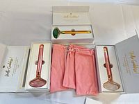 All three facial rollers in boxes with pouches visible
