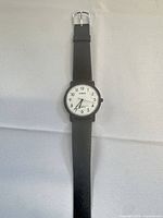 Front view showing white dial, black case, strap