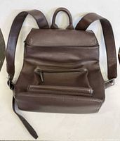 front view of brown leather backpack showing pockets and straps
