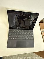 Tablet open with keyboard attached, screen off