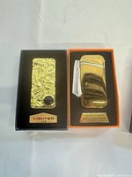Lighters in boxes showing finishes and packaging