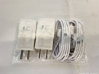 Front view of two white wall chargers and two USB-C cables sealed together