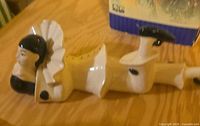 Full length view of porcelain figurine lying on stomach