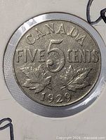 Reverse side of 1929 Canada 5-cent coin showing denomination and maple leaves