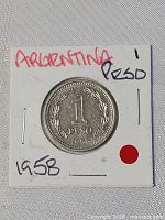 Reverse of coin showing 1 Peso 1958 within wreath, holder marked Argentina