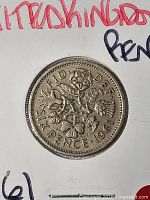 Reverse side of 1961 sixpence coin showing floral emblem design and denomination