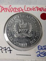Obverse of medallion showing crown, date 1977, wreath and inscription