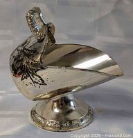 Profile view of silver plate scuttle sugar holder on pedestal
