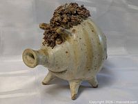 Profile view of stoneware pig with open snout and legs