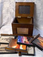 Open wooden photo box with four album inserts displayed