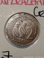 Close-up of coin reverse showing kowhai flowers and numeral 2