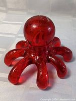 Front angled view of red plastic octopus back massager