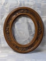 Front view of entire carved wooden oval frame