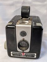 Front view showing lens, viewfinder, nameplate
