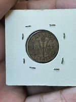Reverse of 1943 Canada 5-cent coin in flip showing V Victory torch design