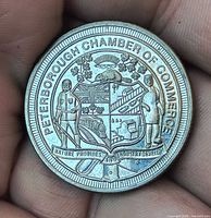 Reverse side showing Peterborough Chamber of Commerce coat of arms and motto
