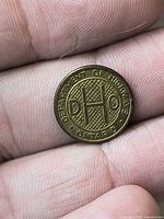 Obverse of brass token with DHO monogram