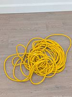 Coiled yellow extension cord showing overall length and colour