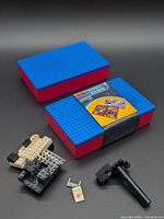 Two blue/red studded storage cases, assorted blocks and tool visible