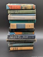 Stack of approximately twelve assorted hardback books showing titles and spine condition