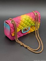 Front and side view of rainbow quilted handbag with chain strap