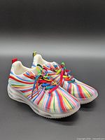 Three-quarter view of pair showing rainbow stripes and laces