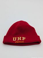 Front view of red beanie showing embroidered text