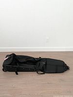 Bag laid open flat on floor showing overall length and wheel assembly
