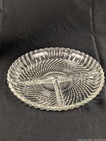 Top view of round clear glass dish showing three compartments and swirl pattern