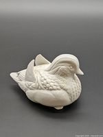 Front-side view of glossy white ceramic mandarin duck figurine