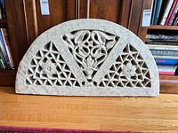 Front view of beige semicircular resin panel showing floral and geometric lattice design