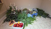 full lot overview on floor shows lattice, floral stems, greenery, basket with faux fruit and gourd