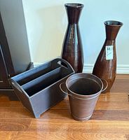Group view of two trumpet vases, faux leather magazine holder, metal flower bucket