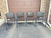 Front view of four metal and wicker patio chairs lined up