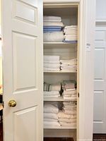Folded towels and bedding on closet shelves