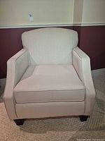 Front view of beige upholstered arm chair
