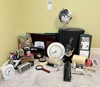 Group shot showing shredder, globe, clocks, calculators, staplers, binders, photo frame and other supplies