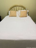Front view of assembled queen bed with headboard, mattress, bedding and pillows