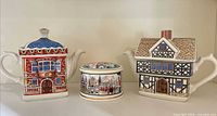Front view of both novelty house teapots and Horseguards trinket box