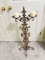 Full view of ornate floor candelabra standing on carpet