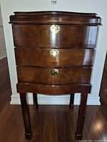Full front view of wooden three-drawer chest on legs
