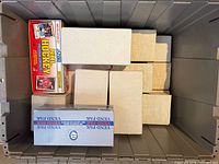 Plastic tote containing several plain storage boxes and two Score Vend Pak boxes