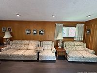 3-seater sofa, armchair and part of loveseat side by side against wood-panel wall