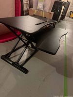 Side view showing X-frame mechanism, upper platform, keyboard tray
