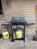 Full view of Broil-Mate grill on cart with two propane tanks