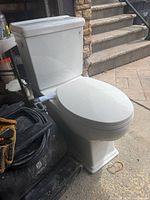 Front view of assembled white two-piece toilet showing tank, bowl and seat