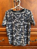 front view of camo knit short-sleeve top on hanger