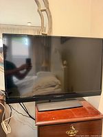 Front view of Insignia TV on nightstand with cables visible