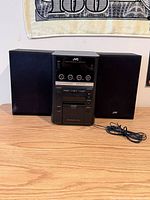 Front view of main unit flanked by two speakers with power cord visible