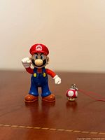Front view of Mario figure standing beside mushroom charm